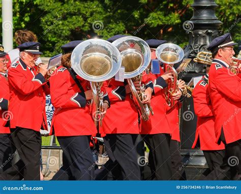 Brass Section Of Marching Band In Red And Blue Uniforms Passing With