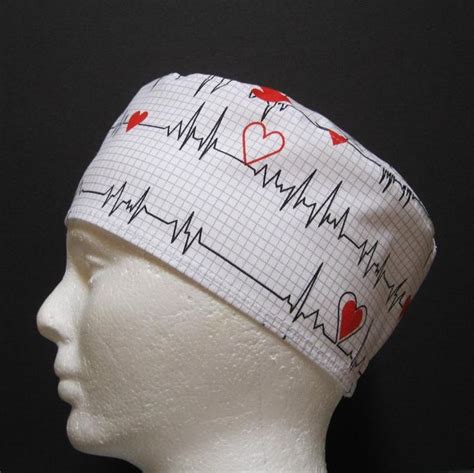 A White Mannequin Head Wearing A Medical Scrub Hat With Red Hearts On It