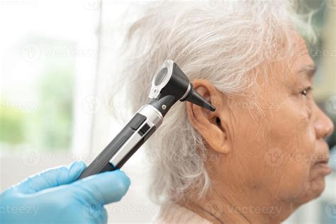 Audiologist Or Ent Doctor Use Otoscope Checking Ear Of Asian Senior