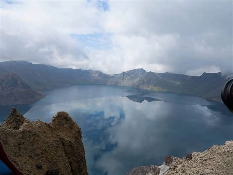 无人横图俯视室外白天旅游度假湖湖泊石头美景山山脉水长白山中国亚洲石子湖面景观山峰水流水面乌云云