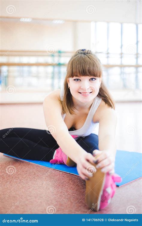 La Mujer Que Hace Estirar Ejercita En El Piso En El Gimnasio Foto De