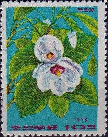 A Stamp With Two White Flowers And Green Leaves