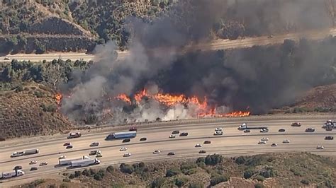 Cars pass by brush fire burning in Los Angeles National Forest | US News | Sky News