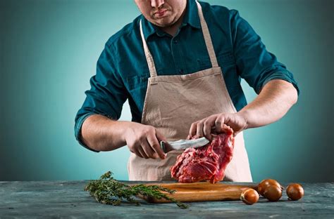 Carnicero Cortando Carne De Cerdo En La Cocina Foto Gratis