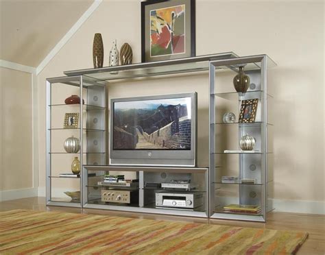 An Entertainment Center With Glass Shelves And A Flat Screen Tv