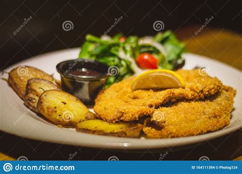 Munich Style` Schnitzel Breaded And Buttered Deep Fried Porkloin Served With Greens Dijon