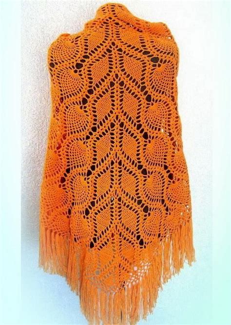 An Orange Crocheted Shawl Hanging On A Wall