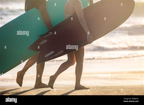 Surfers Carrying Surf Boards Walking The Beach In Bali Indonesia Stock