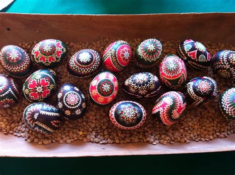 a box filled with lots of painted eggs sitting on top of lentils next ...