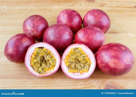 Pair Of Cut In Half Fresh Ripe Passion Fruit With A Pile Of Whole