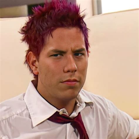 A Man With Red Hair Wearing A White Shirt And Tie Sitting On A Beige Couch