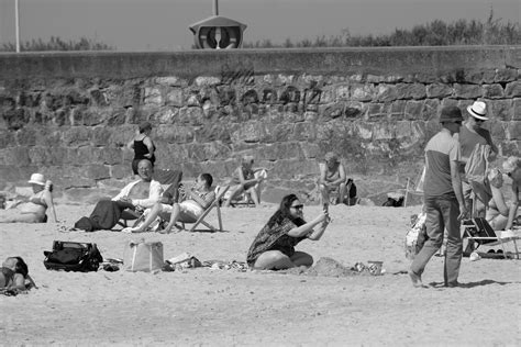 Black and White Beachgoers Relax Under SunFree Stock Photo