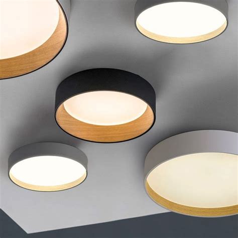 four circular lights hanging from the ceiling in a room with grey walls ...