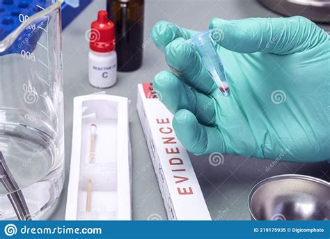 Police Scientist Holds Vial With Blood Trace On Swab To Investigate