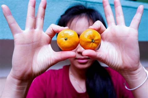 Premium Photo Close Up Of Woman Holding Orange Over Eyes