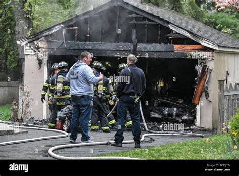 Firefighters Investigate The Scene Fire Destroys Vehicle Inside Of A