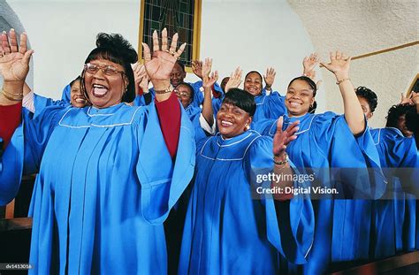 Twelve Gospel Singers With Raised Hands Singing In A Church Service