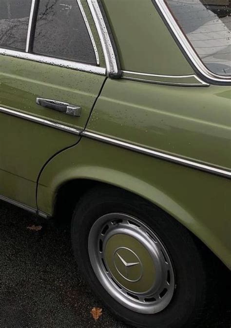 An Old Green Car Is Parked On The Street