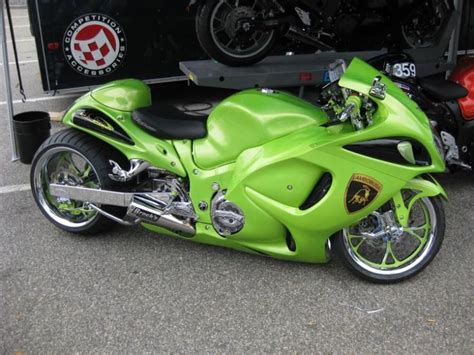 A Green Motorcycle Parked In Front Of A Truck