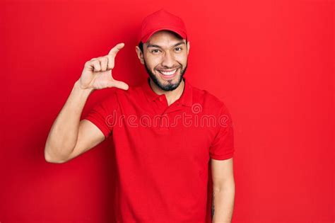 Hispanic Man With Beard Wearing Delivery Uniform And Cap Smiling And