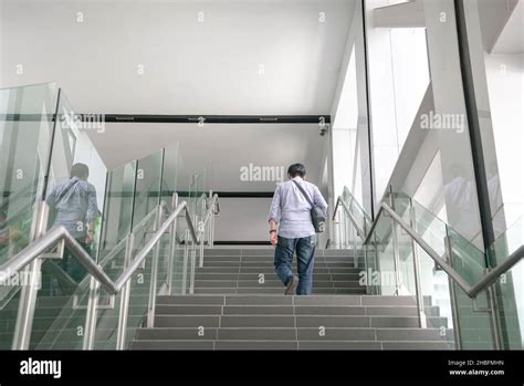 Back View Of Man Walking Up The Stairs Inside A Subway Building