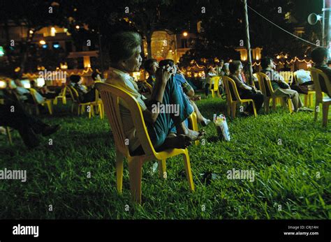 People watch at night before the stage of a street theater in Singapore ...