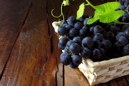 Cachos De Uvas Dentro Da Cesta De Fibra De Bambu Na Mesa De Madeira