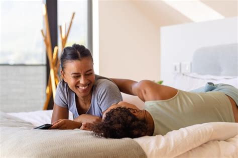 Um Casal Feliz De L Sbicas Biraciais Abra Ando Se E Usando O Smartphone