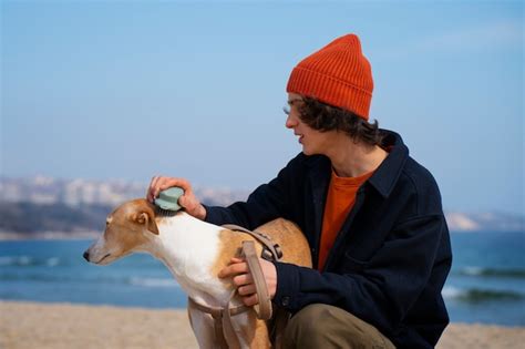 Perro Galgo Con Due O Masculino En La Playa Foto Gratis