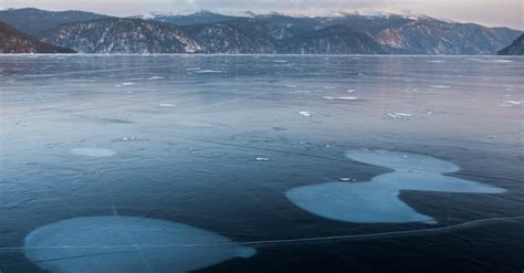 icy lake surrounded  mountains  winter  stock photo