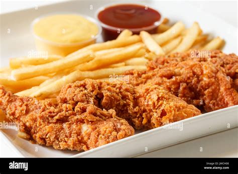 Los Dedos De Pollo Frito Con Patatas Fritas Y Salsa Fotografía De Stock