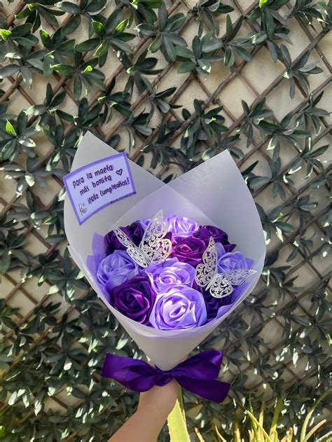 A Person Holding A Bouquet Of Purple Roses