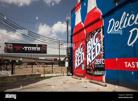 Slanted View Of A Soft Drink Brand Mural With A Sports Ad On A