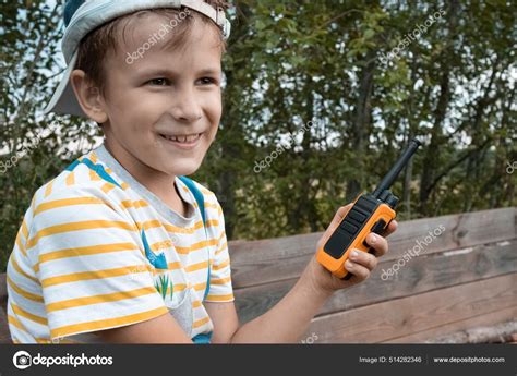 Happy 8 Years Old Boy Playing Outside In Park With Walkie Talkie Radio