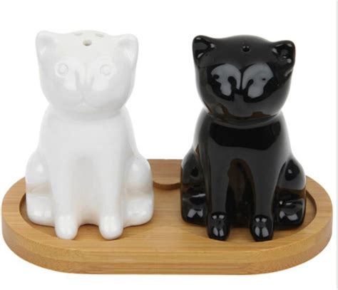 Two Black And White Cat Figurines Sitting On A Wooden Tray