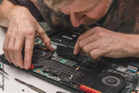 repairman checks laptop cooling system before disassembling, checking ...