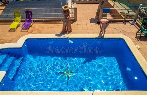 Two Female Friends And Lesbian Couple Cleaning A Swimming Pool Together