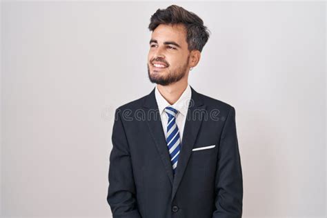 Young Hispanic Man With Tattoos Wearing Business Suit And Tie Looking