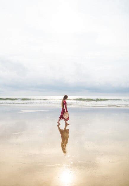 Premium Photo A Woman Walks Along The Beach In The Evening