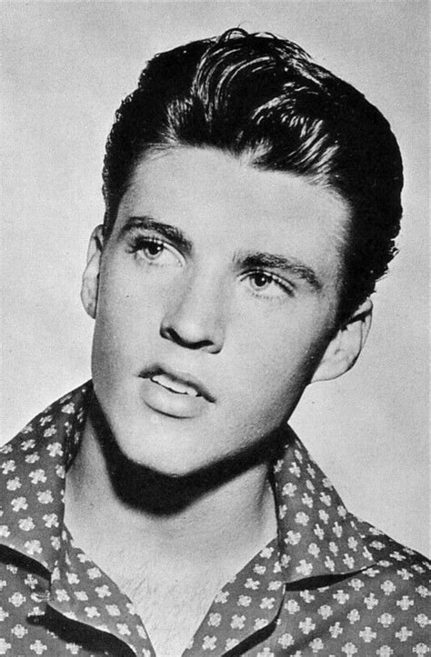 An Old Black And White Photo Of A Man With Short Hair Wearing A Patterned Shirt