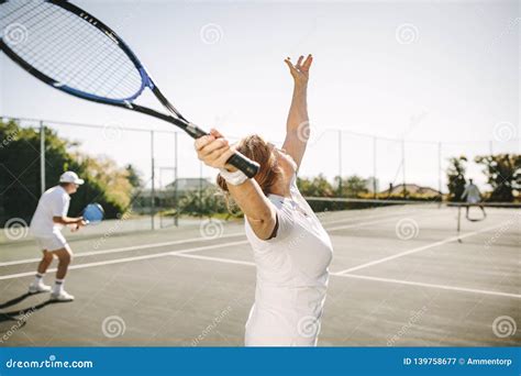 Senior Woman Making A Serve While Playing Tennis Stock Image Image Of