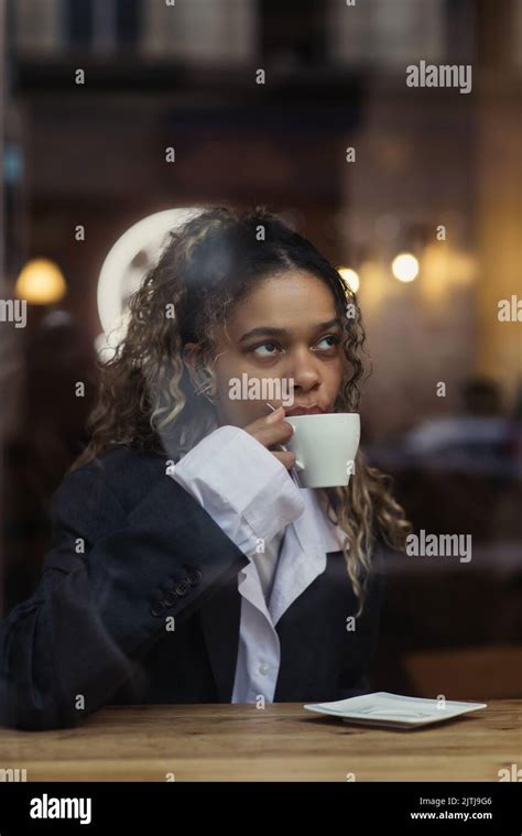 Stylish African American Woman Drinking Coffee From Cup Behind Window