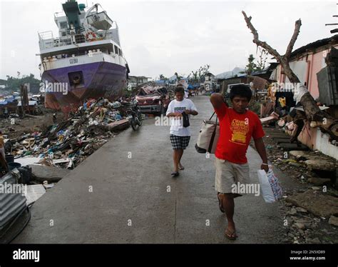 Typhoon Survivors Walk Near Shipping Vessels That Remain Grounded After