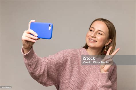 Young Woman Take Selfie Photo On Smartphone Showing Peace V Sign Smile