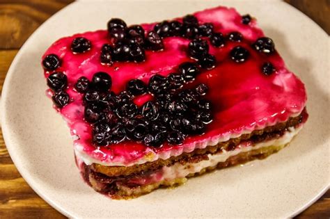 Sabrosa Tarta De Queso Con Grosella Negra Sobre Mesa De Madera Foto