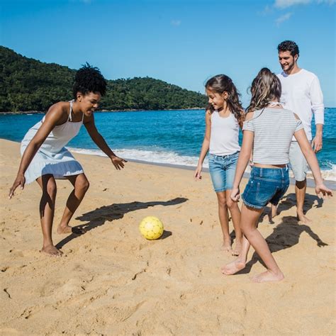 Pais brincando suas filhas na praia Foto Grátis