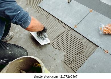 Professional Construction Worker Tiler Laying Adhesive Stock Photo