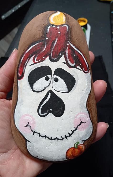 A Hand Painted Rock With A Face On It