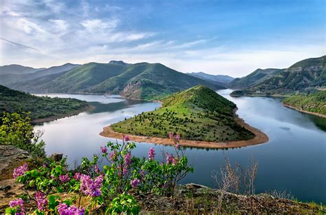 Green Mountain Surrounded By Body Of Water Photo Free Stock Photo