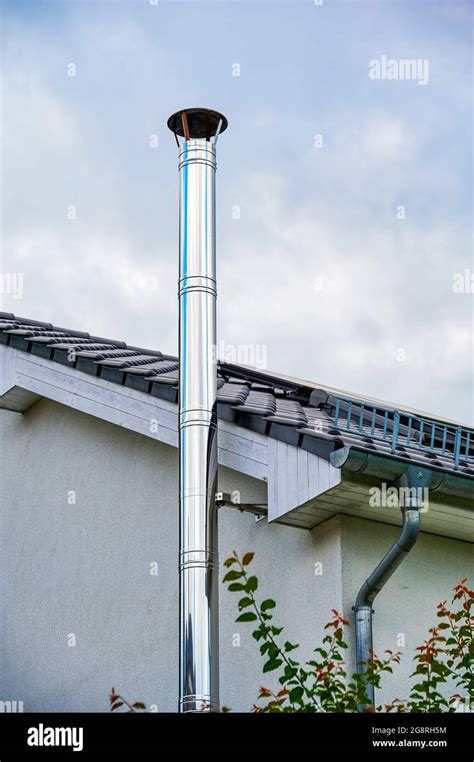 A Stainless Steel Chimney With Parts Of Facade And Roof Stock Photo Alamy